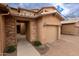 Charming townhome featuring a private garage, stone accents, and neutral stucco exterior at 29120 N 22Nd Ave # 205, Phoenix, AZ 85085