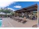 Poolside lounge area with seating, fireplace, clock, and mountain views beyond the lush landscaping at 29120 N 22Nd Ave # 205, Phoenix, AZ 85085