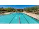 Large swimming pool with marked lanes, surrounded by lounge chairs, landscaping, and mountain views at 29120 N 22Nd Ave # 205, Phoenix, AZ 85085