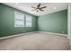 Large, airy green bedroom features a ceiling fan and lots of light from a window at 3200 N 39Th St # 4, Phoenix, AZ 85018