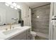 Bathroom with grey vanity, modern fixtures, tiled shower and decorative accents at 3207 W Royal Palm Rd, Phoenix, AZ 85051