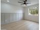 Bright bedroom with light wood floors, board and batten accent wall, ceiling fan and bright window at 3207 W Royal Palm Rd, Phoenix, AZ 85051