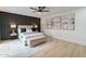 Stylishly furnished main bedroom with a dark accent wall, plush bedding, bench, and decorative artwork at 3207 W Royal Palm Rd, Phoenix, AZ 85051