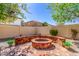 Private backyard with a charming stone fire pit, mature landscaping, and a tranquil ambiance for outdoor gatherings at 3285 E Phelps St, Gilbert, AZ 85295