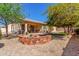 Beautiful backyard featuring a cozy stone fire pit, well-manicured landscaping, and a covered patio for relaxing outdoors at 3285 E Phelps St, Gilbert, AZ 85295