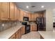 Corner view of kitchen featuring oak cabinetry, black appliances, and tile backsplash plus a floral decor accent at 3285 E Phelps St, Gilbert, AZ 85295