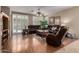Spacious living room with hardwood flooring, leather couches, and natural light from the sliding glass doors at 3285 E Phelps St, Gilbert, AZ 85295