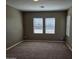 Empty bedroom with neutral walls, plush carpet, and bright natural light from the large windows at 36905 W Mattino Ln, Maricopa, AZ 85138