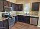 Modern kitchen with stainless steel appliances, dark cabinets, and granite countertops at 36905 W Mattino Ln, Maricopa, AZ 85138