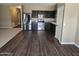 Modern kitchen with stainless steel appliances, dark cabinets, granite countertops, and wood floors at 36905 W Mattino Ln, Maricopa, AZ 85138