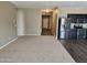 Open-concept living area with carpet and adjacent kitchen with stainless appliances and wood floors at 36905 W Mattino Ln, Maricopa, AZ 85138