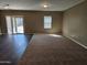 Open-concept living room with sliding glass doors to backyard with mix of wood flooring and carpet at 36905 W Mattino Ln, Maricopa, AZ 85138