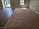 Open-concept living room with sliding glass doors to backyard with mix of wood flooring and carpet at 36905 W Mattino Ln, Maricopa, AZ 85138