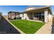 A spacious backyard featuring artificial turf, a covered patio, and desert landscaping at 37783 W San Sisto Ave, Maricopa, AZ 85138