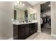 Bathroom featuring double sinks, dark wood cabinets, and a walk-in closet at 37783 W San Sisto Ave, Maricopa, AZ 85138