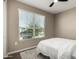 A cozy bedroom featuring a ceiling fan, neutral walls, and a window with blinds at 37783 W San Sisto Ave, Maricopa, AZ 85138