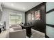 Stylish home office with dark accent wall, modern artwork, and a large desk with seating at 37783 W San Sisto Ave, Maricopa, AZ 85138