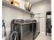 Laundry room with modern washer and dryer, as well as convenient shelving at 37783 W San Sisto Ave, Maricopa, AZ 85138