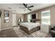 Well-lit main bedroom featuring neutral walls, large bed with storage, and a decorative mirror at 37783 W San Sisto Ave, Maricopa, AZ 85138