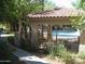 Community pool features a covered seating area with an iron fence surrounded by mature trees and greenery at 3830 E Lakewood Pkwy # 2085, Phoenix, AZ 85048