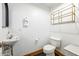 Well-lit half bath with classic fixtures and a decorative storage shelf at 387 N 2Nd Ave # 2E, Phoenix, AZ 85003
