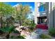 Exterior view showcases a lush courtyard with mature trees and inviting outdoor dining at 387 N 2Nd Ave # 2E, Phoenix, AZ 85003