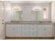 Bathroom with double sinks, granite counters, white cabinets, and modern fixtures at 3901 W Davidson Ln, Phoenix, AZ 85051