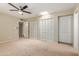 Spacious bedroom featuring a ceiling fan, natural light from a skylight, and ample closet space at 3901 W Davidson Ln, Phoenix, AZ 85051