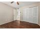 Bedroom with hardwood floors, ceiling fan, and ample closet space at 3901 W Davidson Ln, Phoenix, AZ 85051