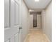 Hallway with beige walls and neutral tile flooring leading to a bedroom with closet space at 3901 W Davidson Ln, Phoenix, AZ 85051