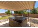 Covered hot tub with a view of the landscaped backyard and perimeter block fencing at 3901 W Davidson Ln, Phoenix, AZ 85051