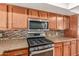 Kitchen featuring stainless steel oven, microwave, backsplash, and light brown cabinets at 3901 W Davidson Ln, Phoenix, AZ 85051
