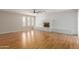 Spacious living room with wood floors, a painted brick fireplace, and lots of natural light at 3901 W Davidson Ln, Phoenix, AZ 85051