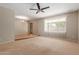 Large living room featuring carpeted floors, a ceiling fan, and a large window overlooking the front yard at 3901 W Davidson Ln, Phoenix, AZ 85051