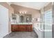 Bright bathroom featuring a dual vanity, soaking tub, and separate glass shower at 41800 W Chambers Ct, Maricopa, AZ 85138