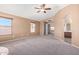 Large bedroom with neutral walls, carpet, fan, and arched windows leading to bath at 41800 W Chambers Ct, Maricopa, AZ 85138