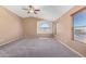 Large bedroom with carpeted floor, vaulted ceiling, ceiling fan, and arched window at 41800 W Chambers Ct, Maricopa, AZ 85138