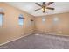 Carpeted bedroom features neutral walls, ceiling fan and arched windows at 41800 W Chambers Ct, Maricopa, AZ 85138