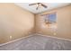 Tan bedroom with a window, ceiling fan, and carpet at 41800 W Chambers Ct, Maricopa, AZ 85138