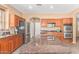 Spacious kitchen featuring dark wood cabinets, granite countertops, and a stainless steel refrigerator at 41800 W Chambers Ct, Maricopa, AZ 85138