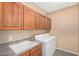 Convenient laundry room featuring ample cabinet space, washer, dryer, and sink area at 41800 W Chambers Ct, Maricopa, AZ 85138