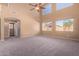 Spacious living room boasts high ceilings, ample windows, and a ceiling fan for comfort at 41800 W Chambers Ct, Maricopa, AZ 85138