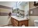 Bathroom featuring double sinks with a large mirror, wood cabinets, and neutral paint at 44715 W Paitilla Ln, Maricopa, AZ 85139