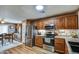 Kitchen showcases wood cabinets, granite countertops, stainless appliances and a dining area at 44715 W Paitilla Ln, Maricopa, AZ 85139