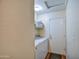 Laundry room featuring white washer/dryer, shelving, and entry door at 44715 W Paitilla Ln, Maricopa, AZ 85139