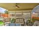 Relaxing covered patio featuring comfortable seating, ceiling fan, and outdoor grill at 44715 W Paitilla Ln, Maricopa, AZ 85139