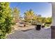Private backyard featuring a cozy lounge area, string lights, mature trees, and lush landscaping, perfect for relaxing at 549 W Sweet Shrub Ave, Queen Creek, AZ 85140