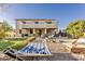 Large backyard featuring a hammock, lawn, a covered patio, lush greenery, and comfortable lounge chairs, great for relaxation at 549 W Sweet Shrub Ave, Queen Creek, AZ 85140