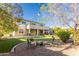 Beautiful backyard with a fire pit, lounge chairs, manicured lawn, covered patio, and mature trees, perfect for gatherings at 549 W Sweet Shrub Ave, Queen Creek, AZ 85140