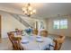 Cozy dining room featuring a chandelier, large window, and seating for eight people at 549 W Sweet Shrub Ave, Queen Creek, AZ 85140